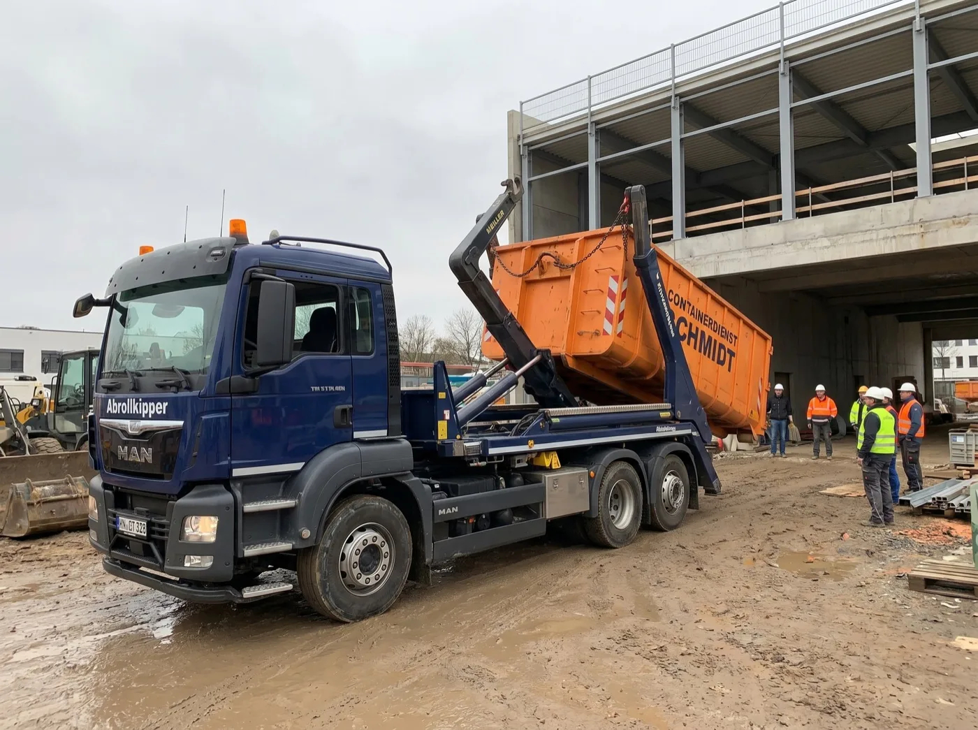 Abrollkipper-LKW setzt eine Mulde an einer Baustelle ab